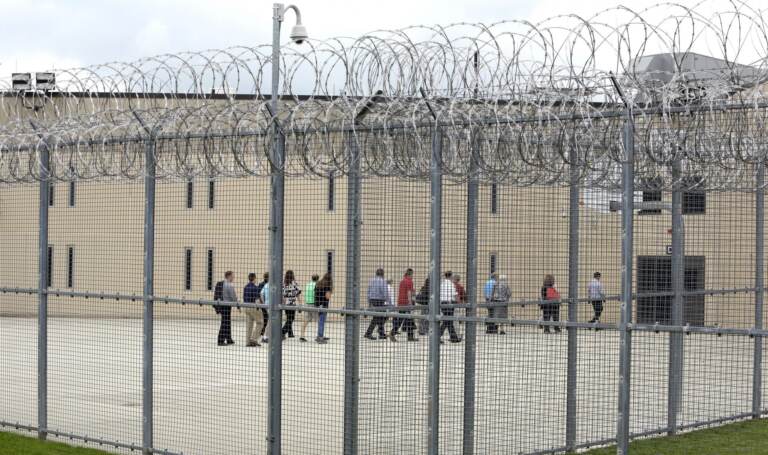 People walk on a tour of the West section of the State Correctional Institution at Phoenix in Collegeville, Pa