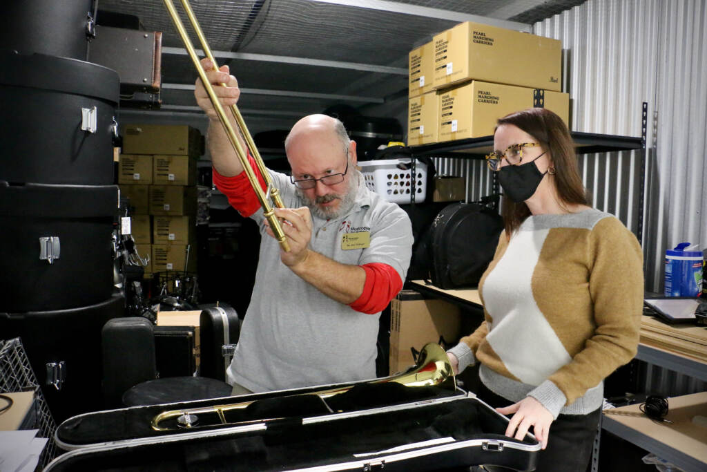 Ken Eidinger, instrument donation liason for Musicopia, inspects a trombone with Musicopia Executive Director Catherine Charlton