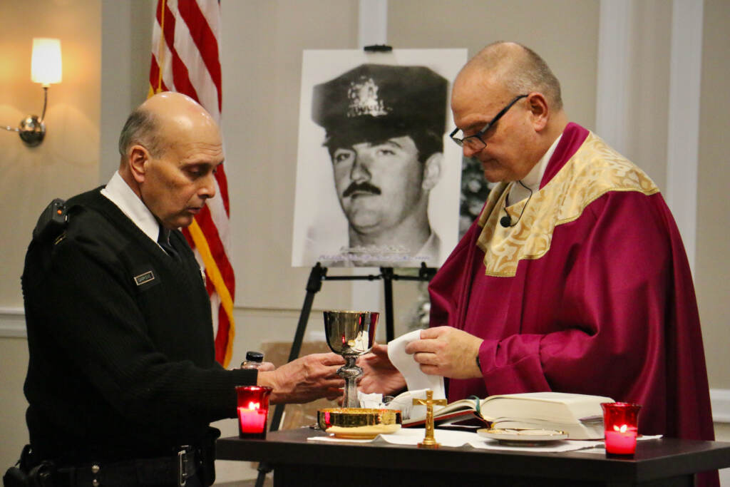 Philadelphia Police Capt. Lou Campione and FOP Chaplain Steven Wetzel prepare communion