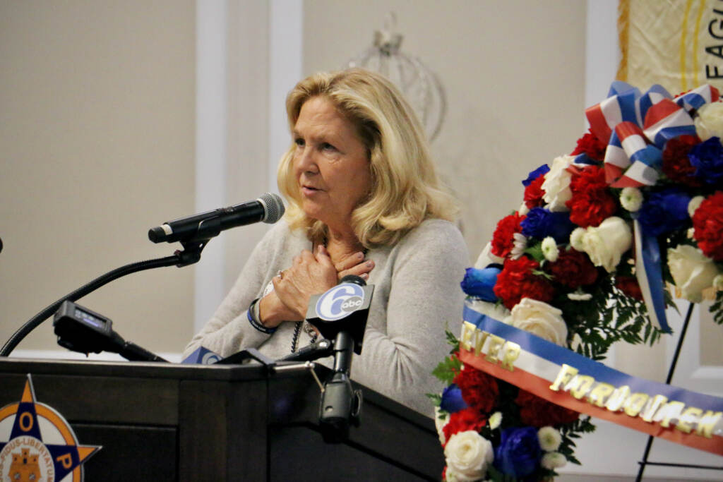 Maurren Faulkner speaks from a podium at a memorial service for her late husband