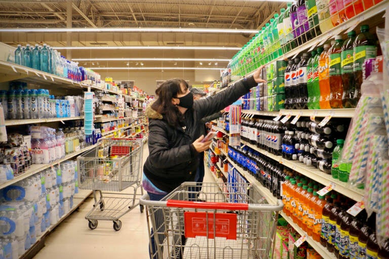 Instacart shopper Christine Meyers reaches for an item at the Giant food store