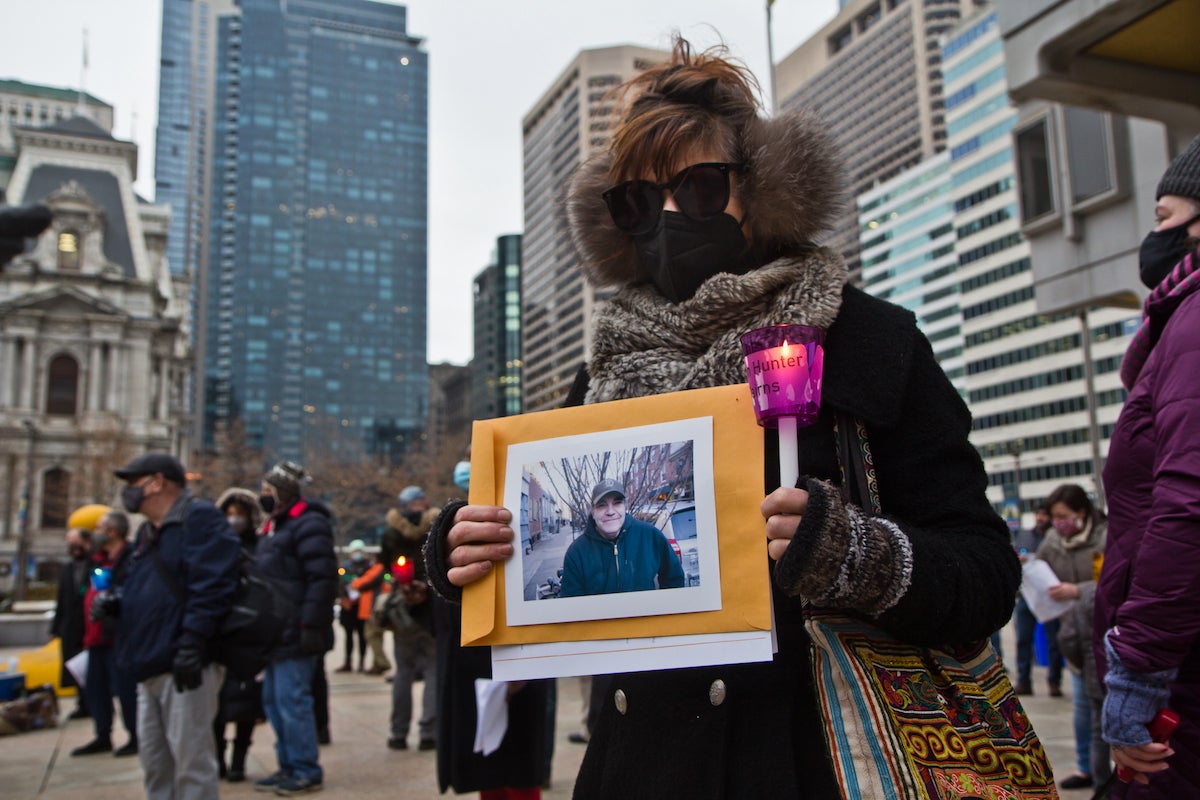 Jody Swietzer holds a portrait of Kelvin Hunter Cairns, who she considered part of her family, at Homeless Memorial Day in Philadelphia