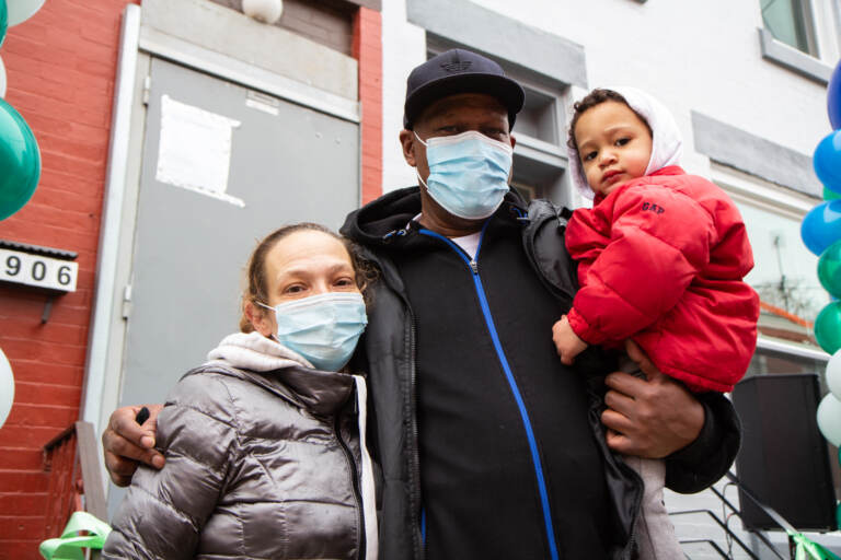 Amanda Payne, Paul Nowell, and their 2-year-old son smile for a photo while wearing masks