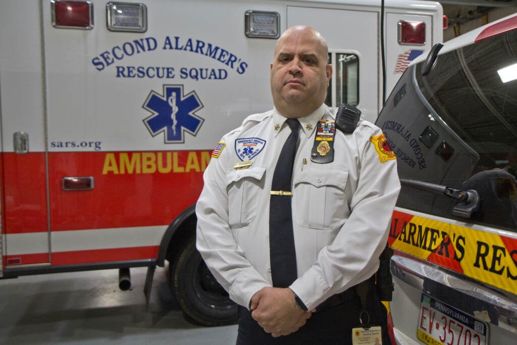 Ken Davidson stands in front of an ambulance