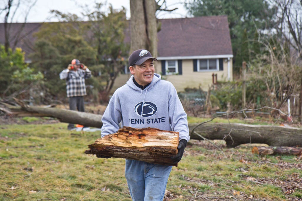 Peter Yoon carries logs from the Warshawer property. He is a volunteer with The Upper Dublin Chainsaw Gang that’s working to clean-up damage from a tornado that tore through the area in September of 2021