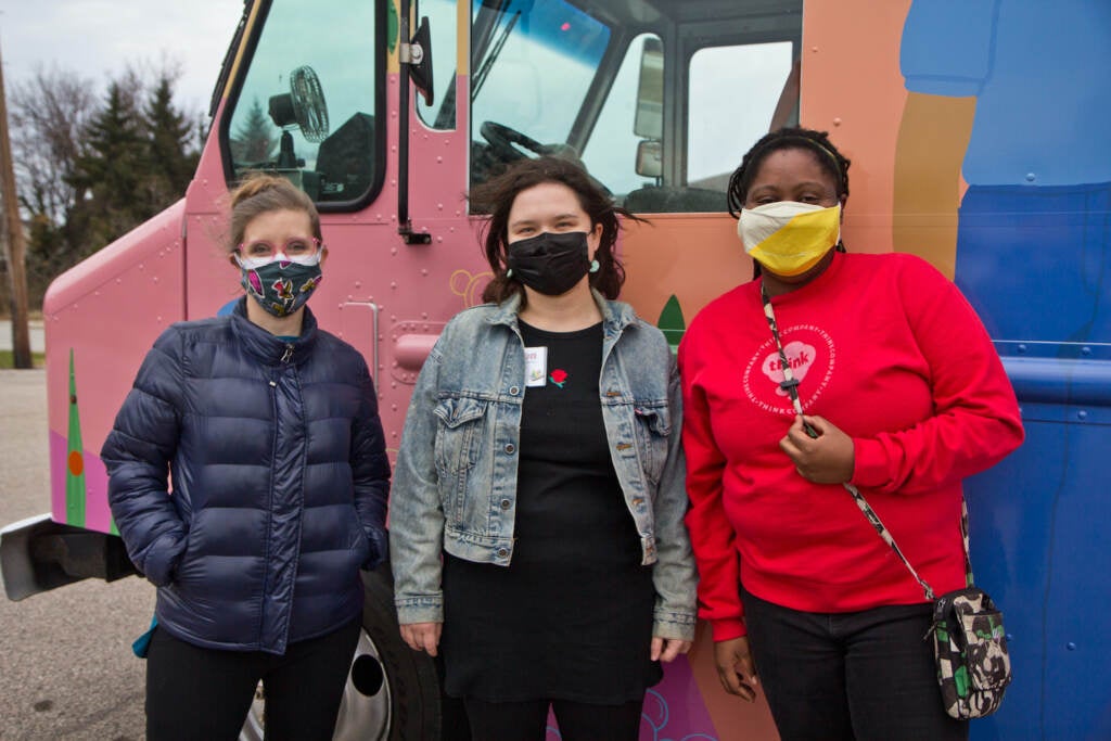 Laure Biron (left), Colleen Hendrick, (center), and Nathalie Cerin stand outside the hygiene truck