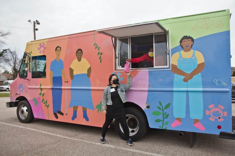 Nathalie Cerin and Colleen Hendrick stand in and outside the hygiene truck