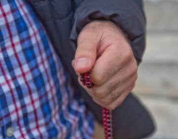 Afghan evacuee Hadi holds the prayer beads he keeps with him in his pocket