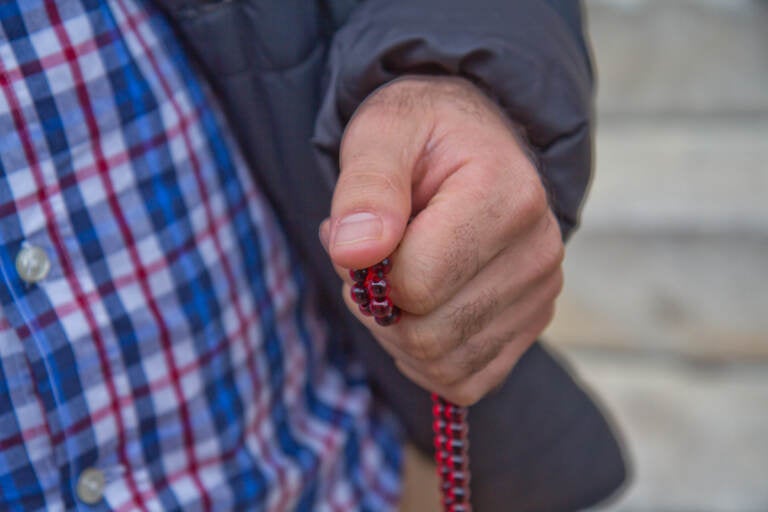 Afghan evacuee Hadi holds the prayer beads he keeps with him in his pocket