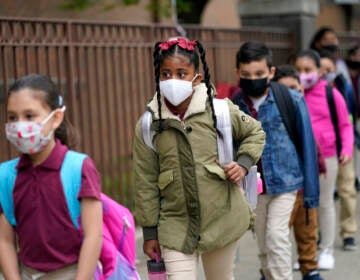 In this April 29, 2021, file photo, students line up to enter Christa McAuliffe School in Jersey City, N.J. Children are having their noses swabbed or saliva sampled at school to test for the coronavirus. As more children return to school buildings this spring, widely varying approaches have emerged on how and whether to test students and staff members for the virus.