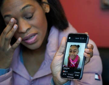 Brittany Tichenor-Cox, holds a photo of her daughter, Isabella 