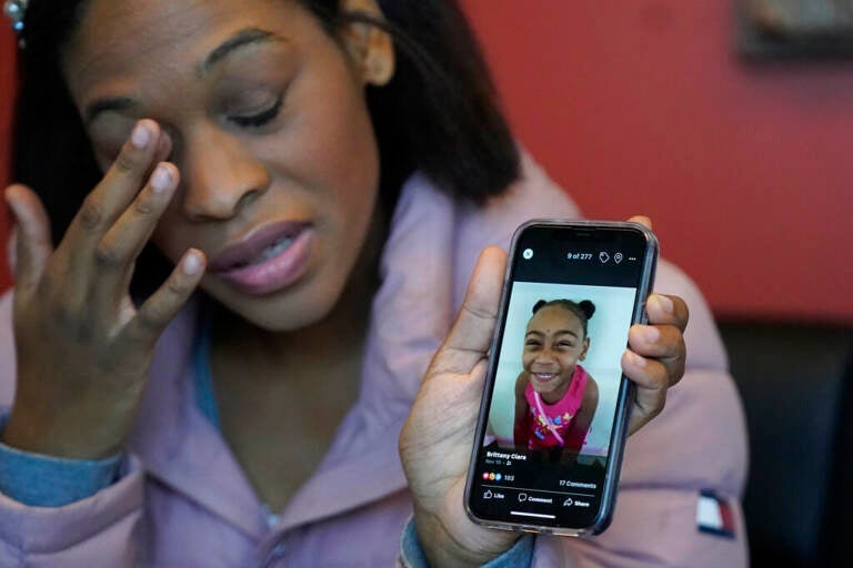 Brittany Tichenor-Cox, holds a photo of her daughter, Isabella 