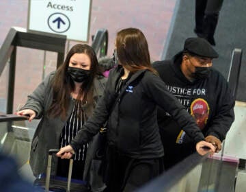 Katie Wright, the mother of Daunte Wright, left, and his father, Arbuey Wright, right, arrive Thursday, Dec. 2, 2021 at the Hennepin County Government Center in Minneapolis for the third day of jury selection for former suburban Minneapolis police officer Kim Potter, who says she meant to grab her Taser instead of her handgun when she shot and killed motorist Daunte Wright. (AP Photo/Jim Mone)