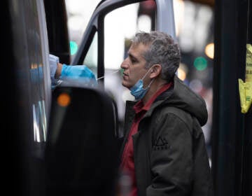 A person takes COVID-19 test at mobile testing site near Grand Central Terminal on Friday, Dec. 3, 2021, in New York. The omicron variant of COVID-19, which had been undetected in the U.S. before the middle of this week, had been discovered in at least five states by the end of Thursday, showing yet again how mutations of the virus can circumnavigate the globe with speed and ease