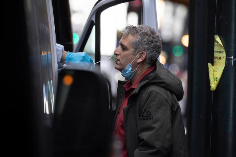 A person takes COVID-19 test at mobile testing site near Grand Central Terminal on Friday, Dec. 3, 2021, in New York. The omicron variant of COVID-19, which had been undetected in the U.S. before the middle of this week, had been discovered in at least five states by the end of Thursday, showing yet again how mutations of the virus can circumnavigate the globe with speed and ease