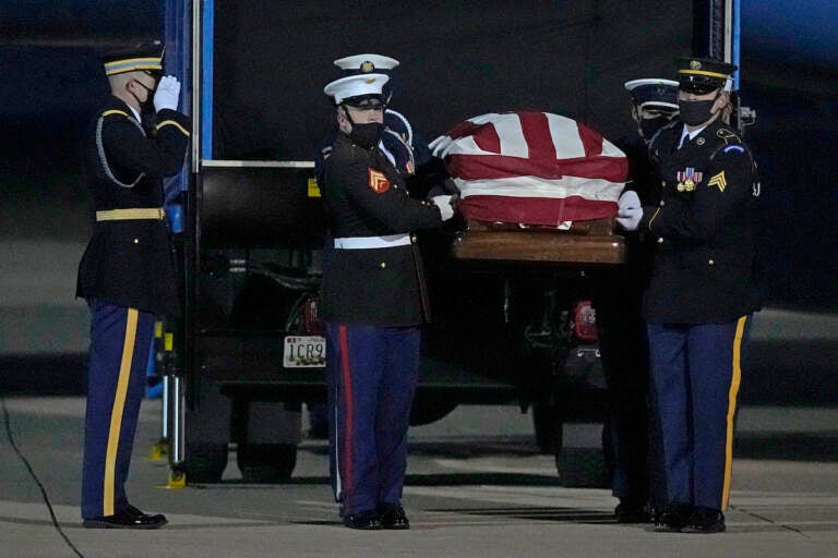 A joint services military bearer team moves the casket of former Sen. Bob Dole, R-Kan., after arriving at the airport in Salina, Kan., Friday, Dec. 10, 2021