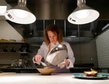 Amy Brandwein, chef and owner of Centrolina, prepares a dish in her restaurant kitchen, Thursday, Dec. 16, 2021, in Washington. While restaurants in the U.S. and United Kingdom are open without restrictions and often bustling, they are entering their second winter of the coronavirus pandemic anxious about what’s ahead. (AP Photo/Patrick Semansky)