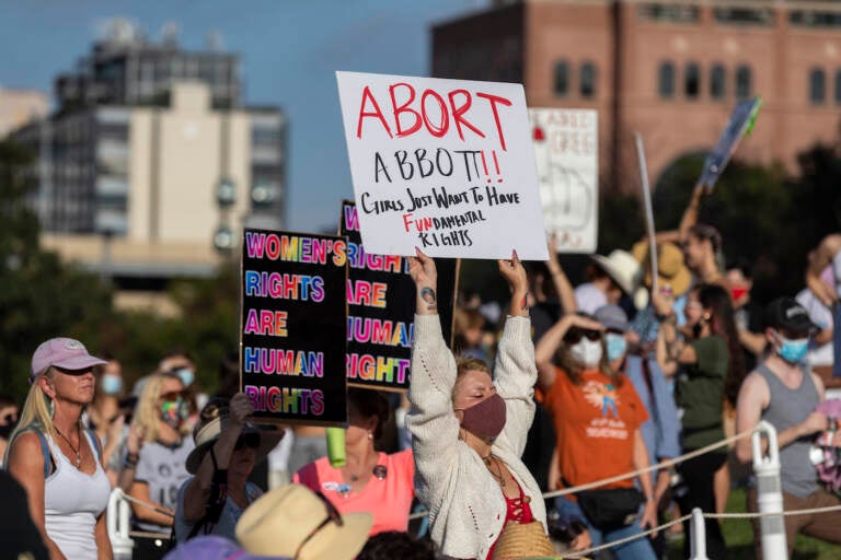 FILE - People attend the Women's March ATX rally, Saturday, Oct., 2, 2021, at the Texas State Capitol in Austin, Texas.  An expected decision by the U.S. Supreme Court in the coming year to severely restrict abortion rights or overturn Roe v. Wade entirely is setting off a renewed round of abortion battles in state legislatures. (AP Photo/Stephen Spillman, File)