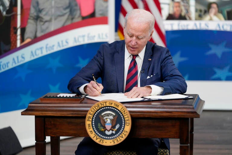 President Joe Biden signs the “Accelerating Access to Critical Therapies for ALS Act” into law during a ceremony in the South Court Auditorium on the White House campus in Washington, Thursday, Dec. 23, 2021.