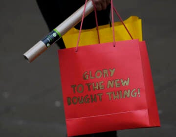 A shopper carries her bags after leaving a department store in Oxford Street on Christmas Eve in London, Friday, Dec. 24, 2021. The emergence of the new COVID-19 omicron variant and the world's desperate and likely futile attempts to keep it at bay are reminders of what scientists have warned for months: The coronavirus will thrive as long as vast parts of the world lack vaccines