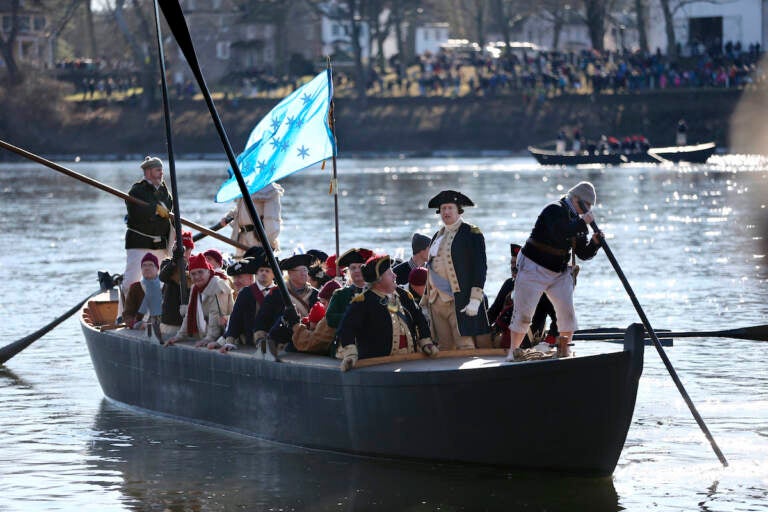 File photo: John Godzieba, as Gen. George Washington, second right, stands in a boat during a re-enactment of Washington's daring Christmas 1776 crossing of the Delaware River in Washington Crossing, Pa., on Dec. 25, 2016. Spectators were once again being invited to gather along the Delaware River to watch an annual reenactment of George Washington’s crossing of the Delaware River on Christmas Day, Saturday, Dec. 25, 2021, a year after an online re-enactment was posted instead. (AP Photo/Mel Evans, File)