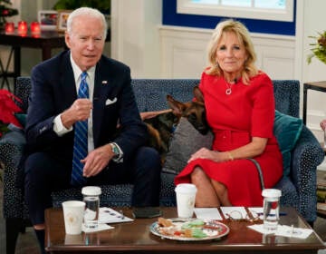 President Joe Biden, first lady Jill Biden and their new dog Commander, a purebred German shepherd puppy, meet virtually with service members around the world, Saturday, Dec. 25, 2021, in the South Court Auditorium on the White House campus in Washington, to thank them for their service and wish them a Merry Christmas