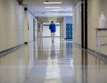A middle school principal walks the empty halls of his school