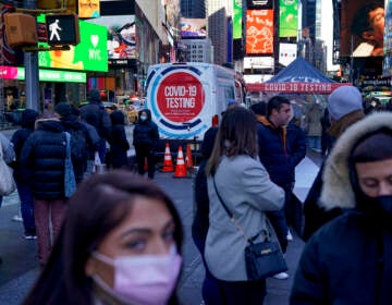 FILE - People wait in a long line to get tested for COVID-19 in Times Square, New York, Dec. 20, 2021. U.S. health officials' decision to shorten the recommended COVID-19 isolation and quarantine period from 10 days to five is drawing criticism from some medical experts and could create confusion among many Americans. (AP Photo/Seth Wenig, file)