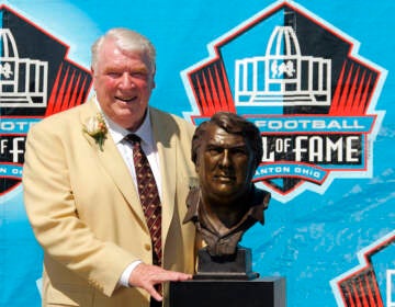 File Photo: Broadcaster and former Oakland Raiders coach John Madden poses with his bust after enshrinement into the Pro Football Hall of Fame Saturday, Aug. 5, 2006, in Canton, Ohio. John Madden, the Hall of Fame coach turned broadcaster whose exuberant calls combined with simple explanations provided a weekly soundtrack to NFL games for three decades, died Tuesday, Dec. 28, 2021, the NFL said. He was 85.