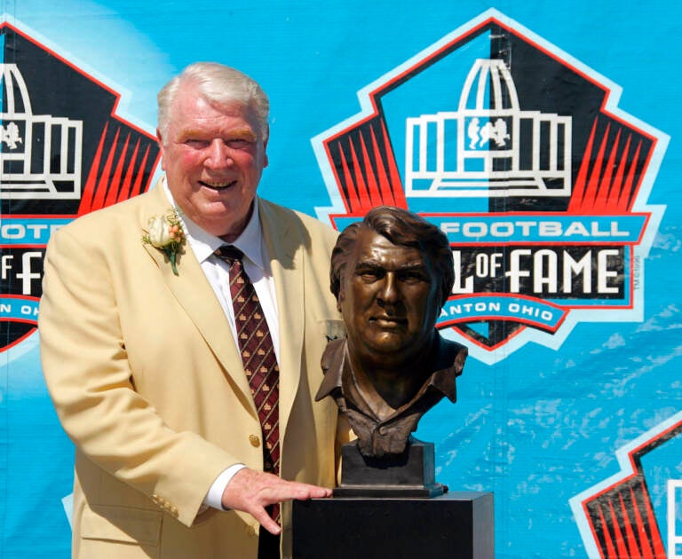 File Photo: Broadcaster and former Oakland Raiders coach John Madden poses with his bust after enshrinement into the Pro Football Hall of Fame Saturday, Aug. 5, 2006, in Canton, Ohio. John Madden, the Hall of Fame coach turned broadcaster whose exuberant calls combined with simple explanations provided a weekly soundtrack to NFL games for three decades, died Tuesday, Dec. 28, 2021, the NFL said. He was 85.