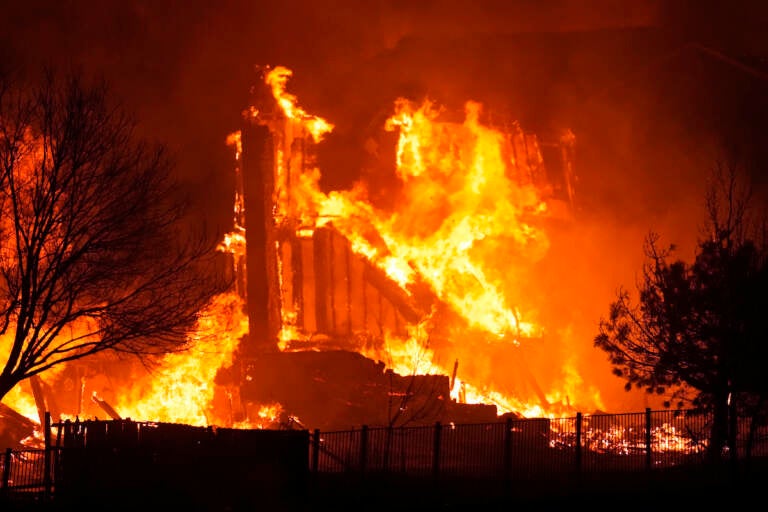 Homes burn as wildfires rip through a development near Rock Creek Village Thursday, Dec. 30, 2021, near Broomfield, Colo. Homes surrounding the Flatiron Crossing mall were being evacuated as wildfires raced through the grasslands as high winds raked the intermountain West
