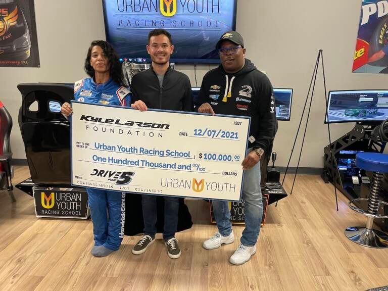 (From left) Michelle Martin, Kyle Larson and Anthony Martin pose with a check from the Kyle Larson Foundation at the Urban Youth Racing School