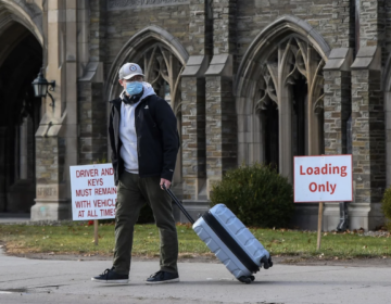 A Cornell University student waits for a ride with luggage in tow at the campus in Ithaca, N.Y., Thursday, Dec. 16. Cornell University abruptly shut down all campus activities on Tuesday and moved final exams online after hundreds of students tested positive over three days.
Heather Ainsworth/AP