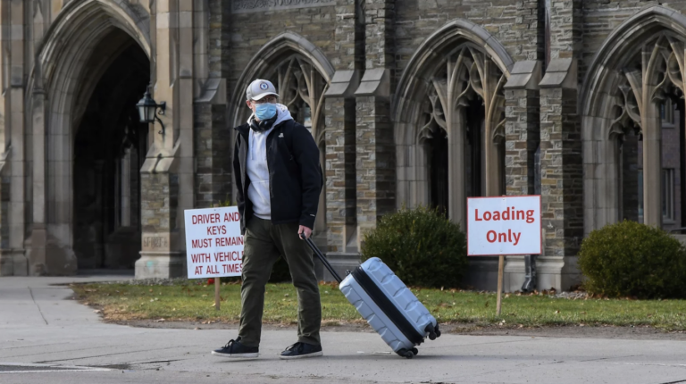 A Cornell University student waits for a ride with luggage in tow at the campus in Ithaca, N.Y., Thursday, Dec. 16. Cornell University abruptly shut down all campus activities on Tuesday and moved final exams online after hundreds of students tested positive over three days.
Heather Ainsworth/AP