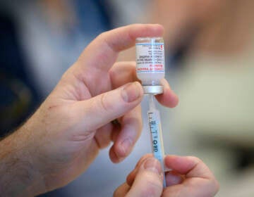 Medical staff and volunteers prepare shots of the Moderna COVID-19 vaccine