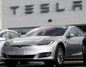 FILE - This July 8, 2018 photo shows Tesla 2018 Model 3 sedans sit on display outside a Tesla showroom in Littleton, Colo. Late last year, Tesla Inc. was fully charged and cruising down the highway on Autopilot. Shares were trading above $370 each, sales of the Model 3 small electric car were strong and the company had appointed a new board chair to rein in the antics of CEO Elon Musk. But around the middle of December 2018, investors started having doubts about the Wall Street darling’s prospects for continued growth. The stock started a gyrating fall that was among the worst in company history
