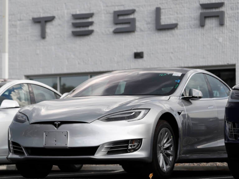 FILE - This July 8, 2018 photo shows Tesla 2018 Model 3 sedans sit on display outside a Tesla showroom in Littleton, Colo. Late last year, Tesla Inc. was fully charged and cruising down the highway on Autopilot. Shares were trading above $370 each, sales of the Model 3 small electric car were strong and the company had appointed a new board chair to rein in the antics of CEO Elon Musk. But around the middle of December 2018, investors started having doubts about the Wall Street darling’s prospects for continued growth. The stock started a gyrating fall that was among the worst in company history