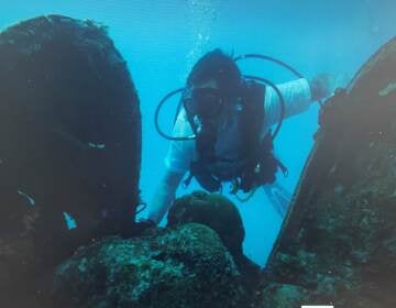 A member of Project Recovery combs through the debris of a downed aircraft found in the Pacific Ocean off Palau. (Project Recover)