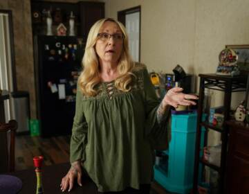 Cheryl Gibson gestures while standing inside her home