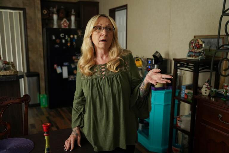 Cheryl Gibson gestures while standing inside her home