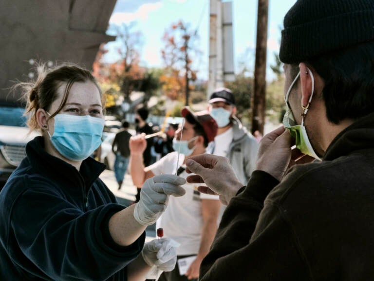 A man is handed a swab for a COVID-19 rapid test