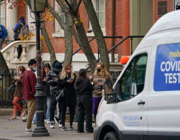 Pedestrians wait in line to get tested for COVID-19