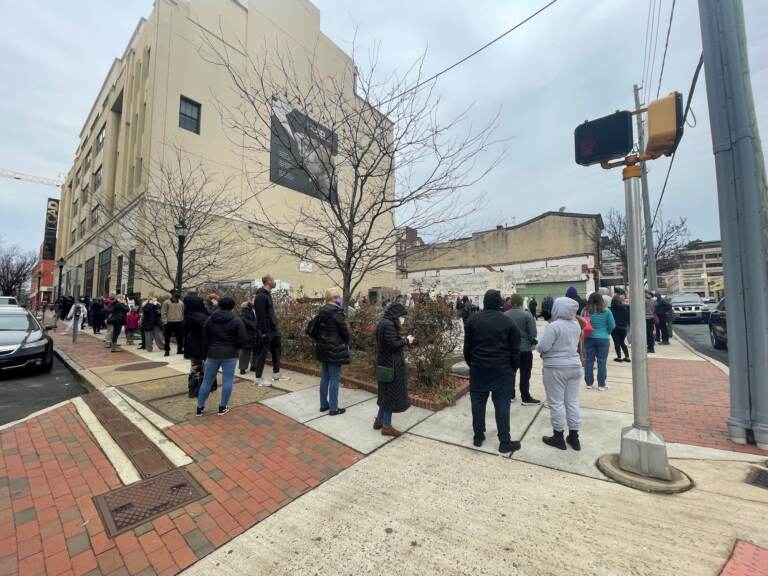 People wrap around the block while waiting in line for COVID-19 testing