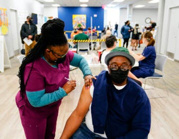 Nurse Sheena Davis administers a dose of a Moderna COVID-19 vaccine