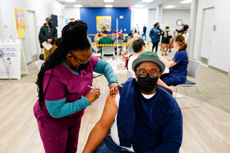 Nurse Sheena Davis administers a dose of a Moderna COVID-19 vaccine