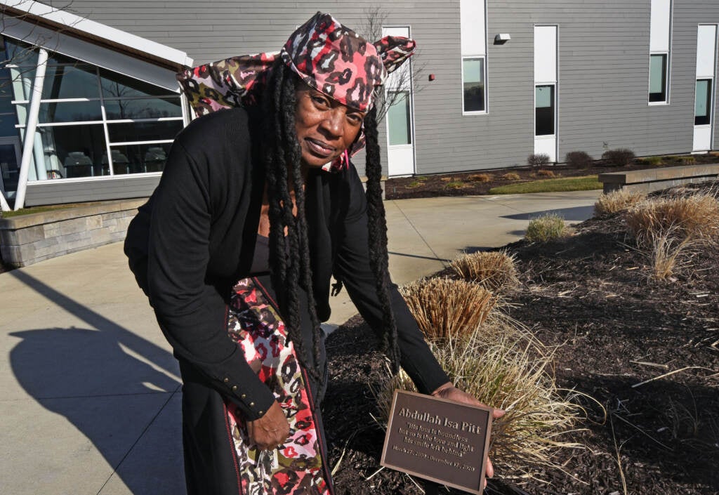 Deborah "Zola" Miles gestures toward a plaque created in her grandson's memory