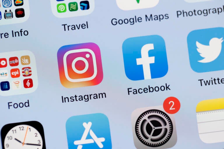 The Facebook and Instagram apps are seen on the screen of an iPhone