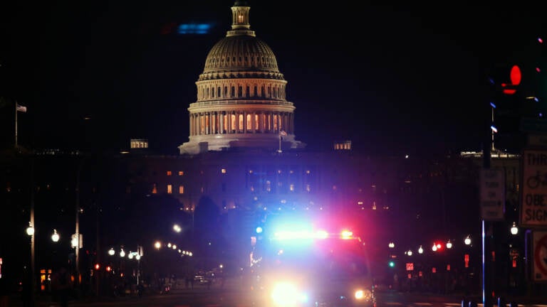 A police car drives away from the Capital after thousands of Donald Trump supporters stormed the United States Capitol building following a 