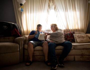 Lisa Stagon sits with her son Chris on the couch