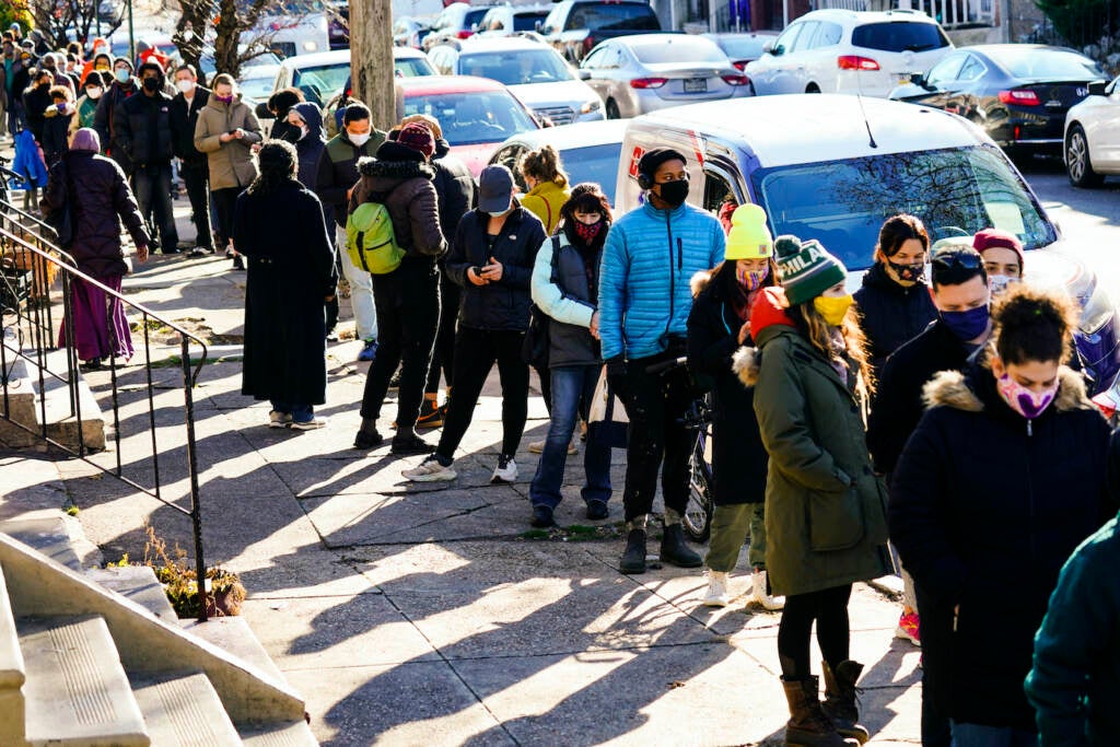 City residents wait in a line extending around the block to receive free at-home rapid COVID-19 test kits in Philadelphia